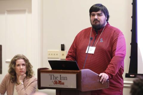 PhD student Andrew Boldt speaks while professor April Holm looks on.