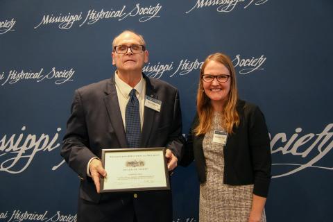 Award of Merit - Catherine C. Myers for compiling a book on the history of Pass Christian. Accepting is Rory Rafferty.
